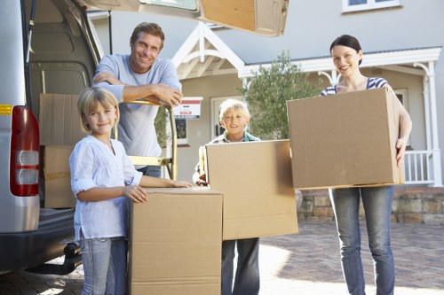 Moving boxes and wrapped furniture prepared for transport in Merton Park