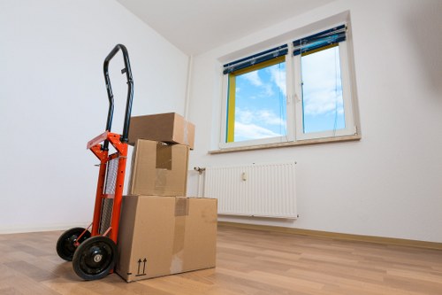 Professional movers carrying furniture during a local home move in Merton Park